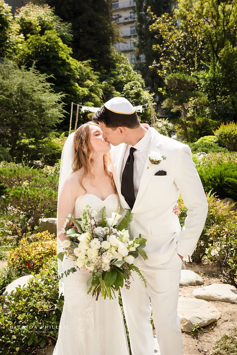 Bride and groom share a kiss after their garden wedding ceremony at JACCC in Los Angeles, CA