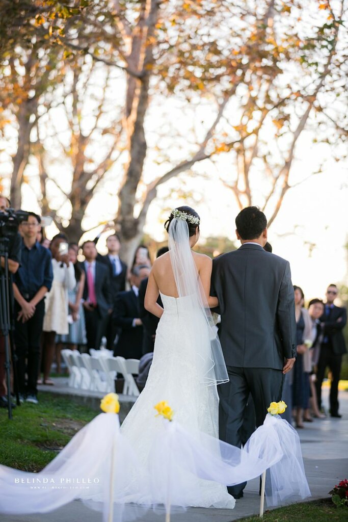 Bride is escorted down the aisle at Summit House wedding in Fullerton, Ca