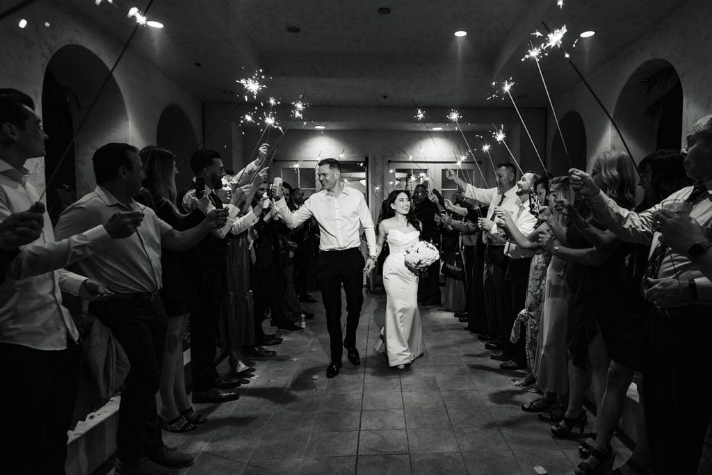 Sparkler exits are popular for weddings at Los Coyotes Country Club in Buena Park, CA. Bride and groom exit the venue as their guests cheer and waive sparklers.