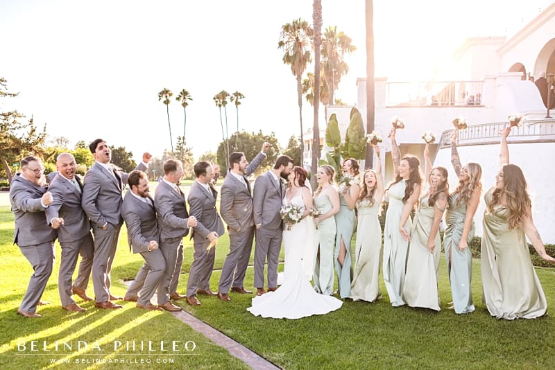 Wedding party cheers as bride and groom kiss during Los Coyotes Country Club wedding